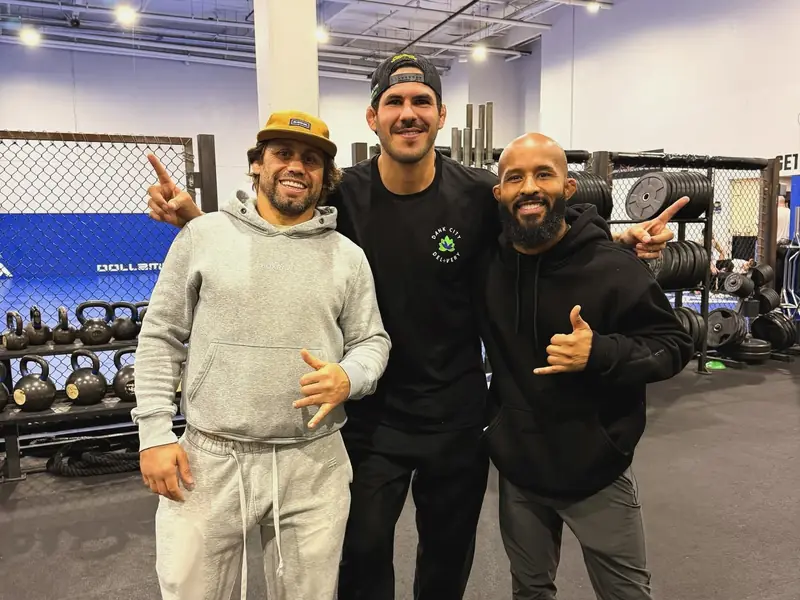 Kevem entre Urijah Faber e Demetrious Johnson, na academia, durante a semana de treinos