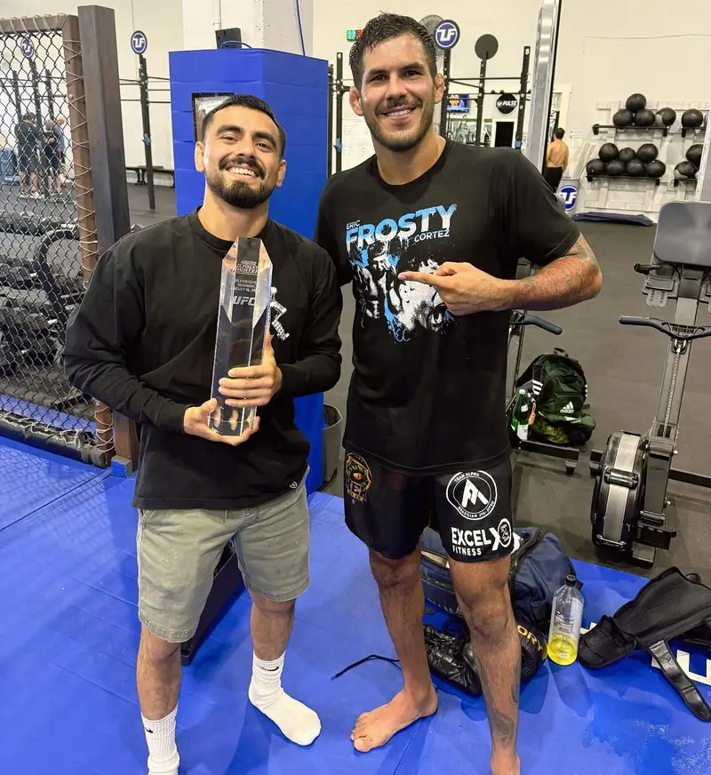 Kevem com um amigo e um troféu na academia