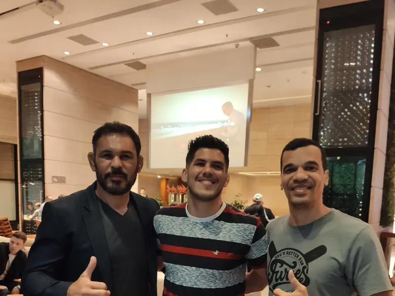 Kevem entre Rodrigo Minotauro Nogueira e outro embaixador do UFC, no saguão do hotel