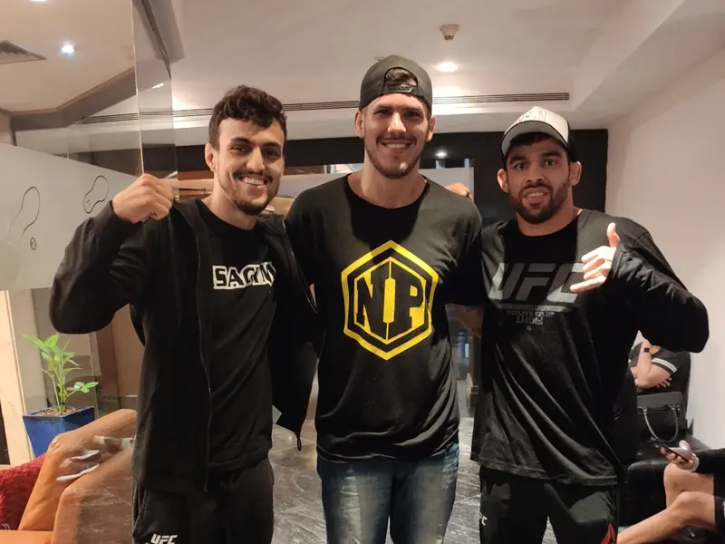 Kevem entre Renan Barão e Ricardo Carcacinha nos bastidores do UFC em São Paulo