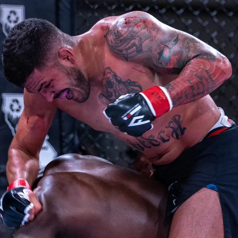 Kevem golpeia o adversário no chão, dentro do cage